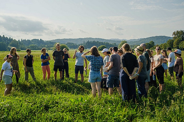 [Translate to Französisch:] Eine Gruppe von Menschen auf einem Feld.